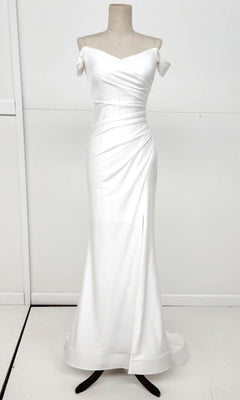 The Off-the-Shoulder Long Prom Dress: Chicas YG5025 is a white, floor-length gown with a fitted bodice and draped detailing, shown on a mannequin against a plain background.