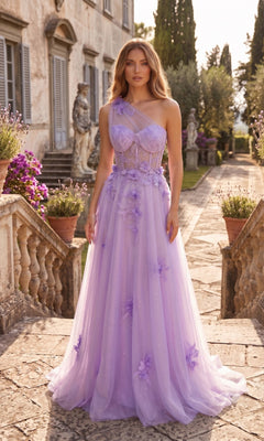 A woman stands outside on stone steps, wearing the Long Prom Dress: Chicas YG5028 in lilac, featuring a one-shoulder design with floral embellishments and an elegant a-line glitter tulle skirt. She poses in front of a classic building and garden.