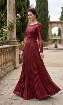 A woman wearing the Chicas YG5031 Long Formal Dress in burgundy, featuring floral and sequin embellishments, stands outdoors on a stone pathway near gardens and columns.