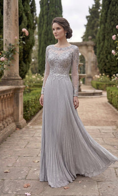A woman wears the Chicas YG5031 long formal dress in silver, a pleated gown with lace details, standing on a stone pathway amidst columns and lush greenery in a formal garden.