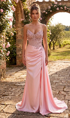 A woman stands on a stone path in a garden filled with roses and greenery, wearing the Long Prom Dress: Chicas YG5041 in baby pink, featuring a fitted beaded bodice and strapless neckline.