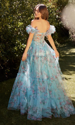 A woman stands outside in the Puff-Sleeve Long Blue Print Prom Dress A1285, featuring a corset-style bodice and off-the-shoulder puff sleeves, surrounded by lush greenery.