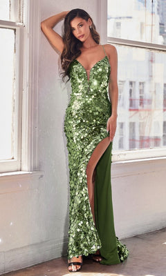 A woman poses indoors near large windows wearing the Unique Corset-Back Long Sequin Prom Dress B1141, a sleeveless green gown with sparkling sequins and a thigh-high slit.