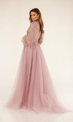 A woman models the Cecilia Couture C273 long formal dress, featuring a light pink hue, sheer sleeves, sequin details, and a flowing removable tulle overskirt against a plain light background.