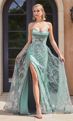 A woman stands outside in front of arched glass doors, wearing the Strapless Long Glitter-Print Prom Dress CB129 in light green, featuring a high slit and sheer glitter print overlay.