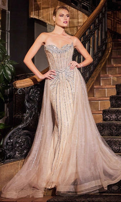 A woman stands on a staircase wearing the Ladivine CB158, a strapless glitter-tulle prom gown with a sweetheart neckline, floor-length design, and shimmering embellishments.