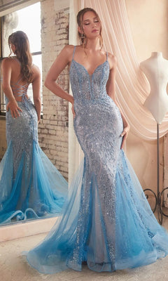 A woman poses in front of a mirror wearing the Low V-Neck Long Glitter Mermaid Prom Dress CC2253, a sparkly blue gown with thin straps and a sheer overlay, in a softly lit room.