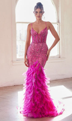 A woman poses indoors by a sunlit window, elegantly wearing the Feather-Trim Long Beaded Mermaid Prom Dress CC2308, featuring a fitted silhouette adorned with beads and pink feather details at the hem.