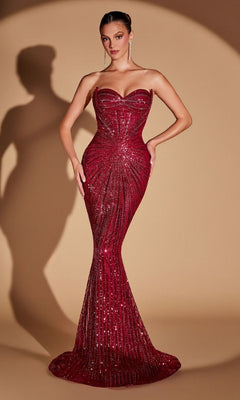A woman in the strapless, form-fitting Ladivine CD0108 long prom dress in burgundy poses against a beige background with a shadow behind her, the sparkling sequins of her stunning gown catching the light beautifully.