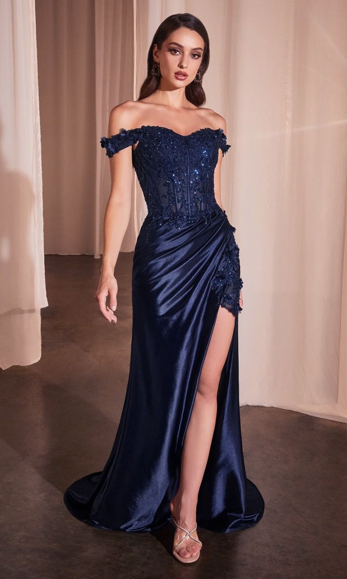 A woman models the Off-the-Shoulder Long Sweetheart Prom Dress CD0186, a navy blue gown with sequin details and a thigh-high slit, while standing indoors on a concrete floor.