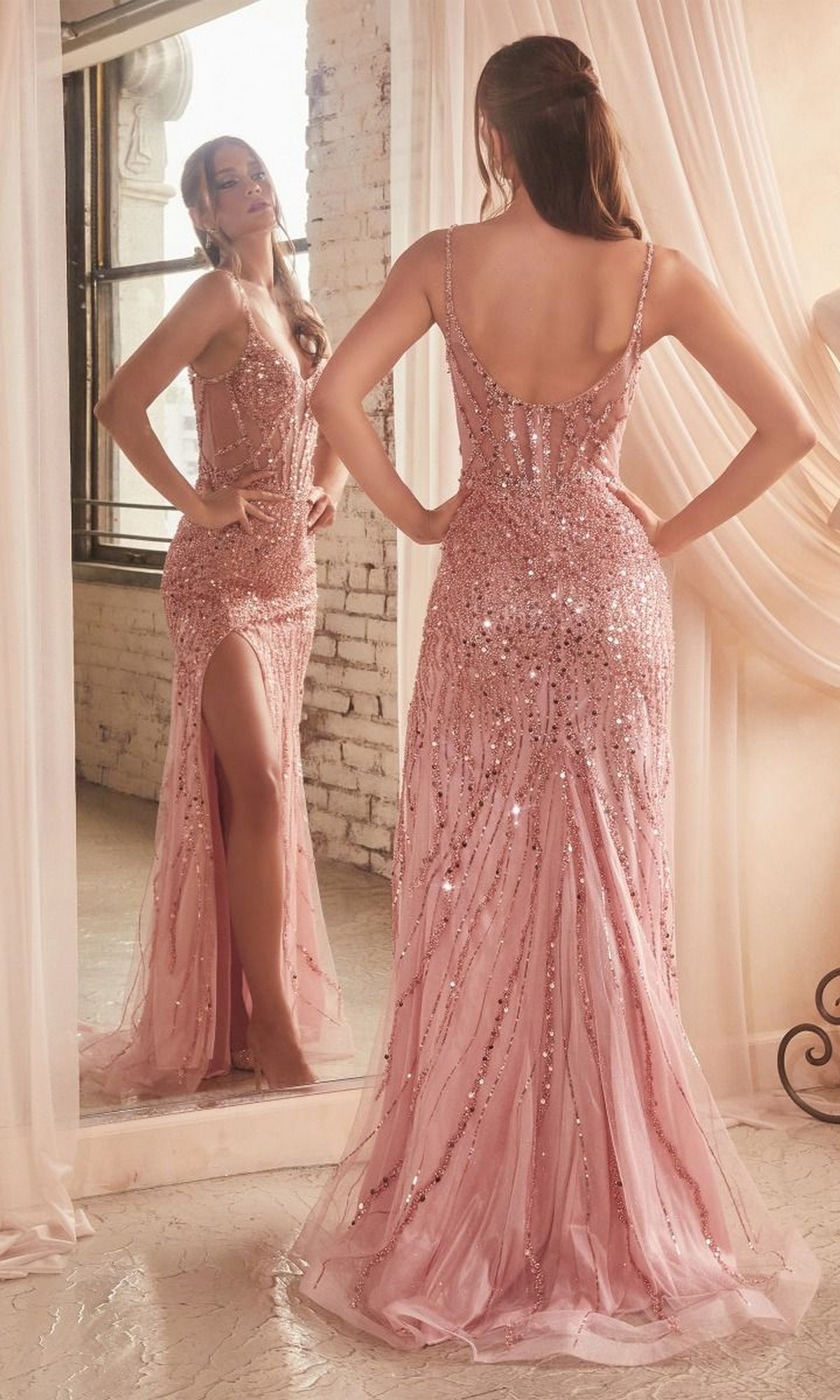 A woman stands before a mirror in the Sheer-Bodice Long Beaded Prom Dress CD0220, flaunting its eye-catching beaded design, pink sequins, floor-length silhouette, and thigh-high slit that highlights the elegant back of her formal gown.
