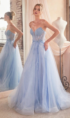 A woman stands before a mirror in the Strapless Sheer-Corset Long Prom Ball Gown CD0230, a light blue dress with a beaded sheer bodice, beside a dress form in a gently lit room.