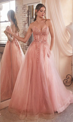 A woman in the Strapless Sheer-Corset Long Prom Ball Gown CD0230, featuring a fitted embellished bodice and full glitter tulle skirt, stands in a softly lit room with draped curtains and a large mirror.