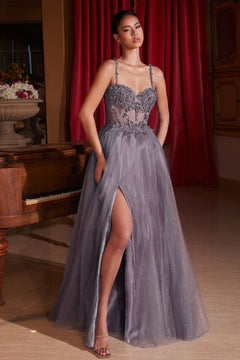 A woman stands indoors wearing the Glitter-Tulle Long Prom Dress: Ladivine CD0234, a floor-length lavender gown featuring an embellished sweetheart bodice, floral accents, and a thigh-high slit.