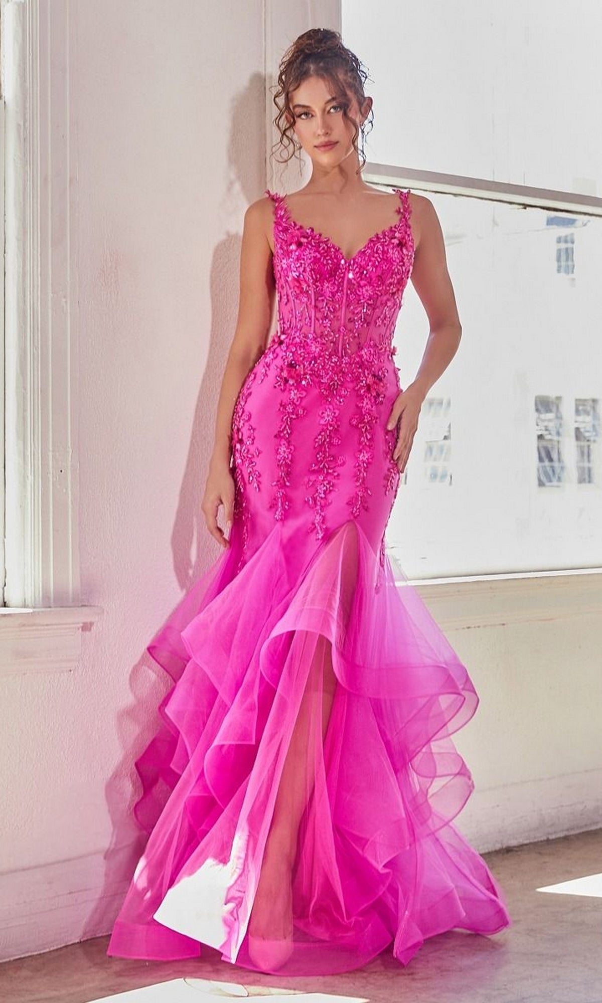 A woman stands indoors wearing the Bright Fuchsia Pink Long Mermaid Prom Dress CD331, featuring beaded lace appliqué, a layered ruffled tulle skirt, and elegant floral embellishments.