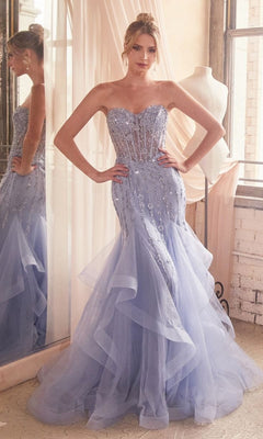 A woman poses indoors wearing the Strapless Sweetheart Long Mermaid Prom Dress CD332, a light blue tulle gown with beaded embellishments and a fitted bodice.