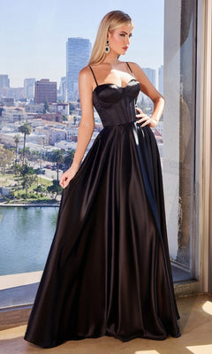 A woman in the Ladivine CD337 Long Sweetheart A-Line Prom Dress, featuring thin straps and a corset bodice, stands by a window overlooking the city during daylight.