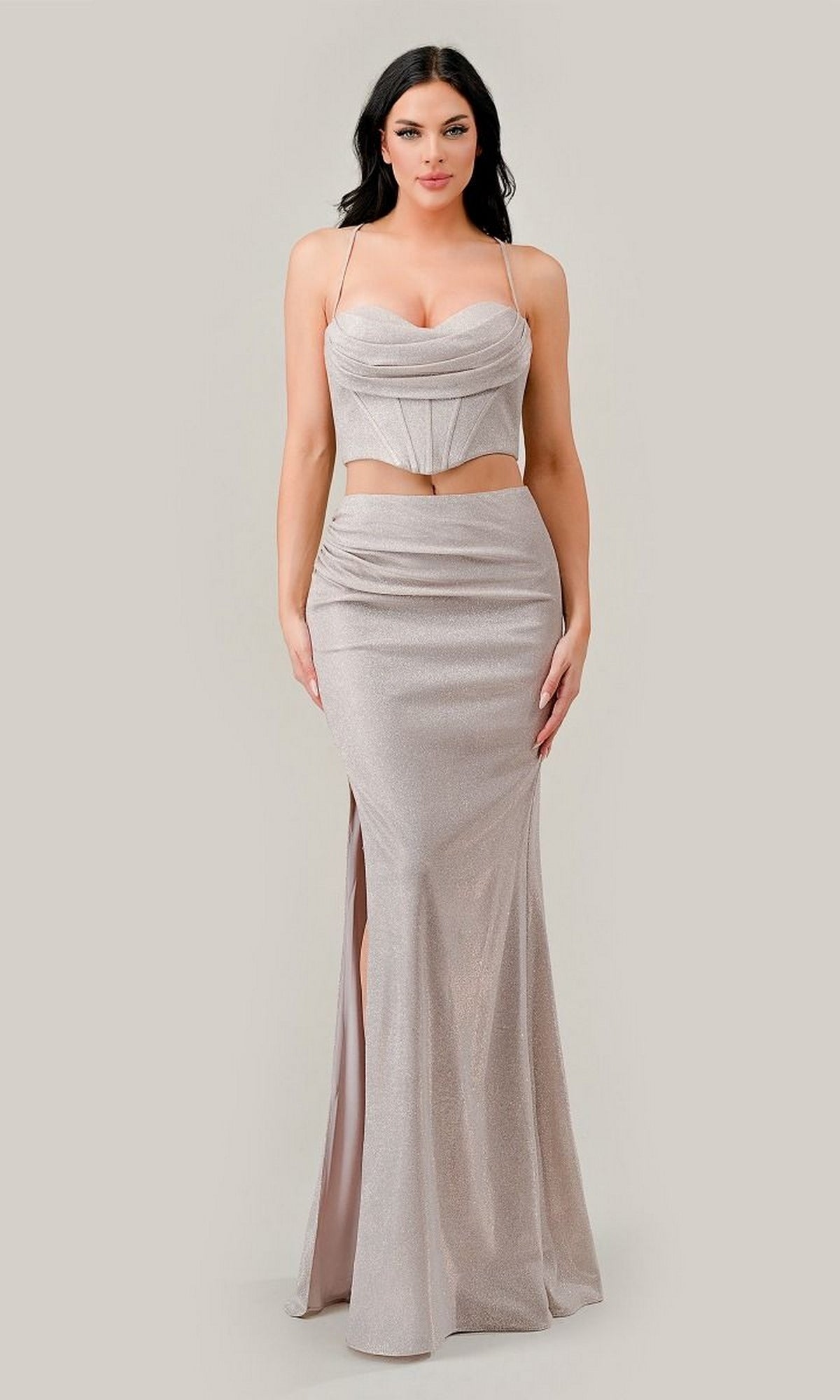 A woman stands against a neutral background wearing the Ladivine CD350, a two-piece long glitter prom dress featuring silver ombre shimmer, thin straps, a fitted bodice with cut-out waist, high slit, and floor-length skirt.