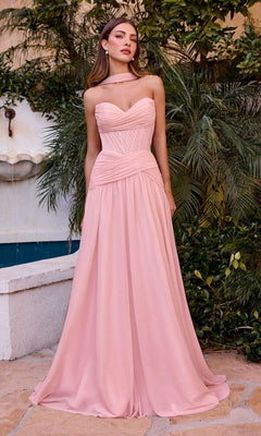 A woman stands outdoors in the Ladivine CD395, a light pink strapless prom dress with a fitted corset bodice and elegant A-line skirt. Green plants and a white wall complete the background.