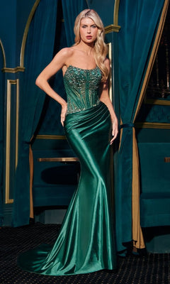 A woman in the emerald green Strapless Long Corset Prom Dress: Ladivine CD725 stands in an elegant room with dark teal curtains and gold accents.