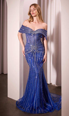 A woman wears the Ladivine CD785B royal blue long beaded prom dress, featuring silver stripes and embellishments, standing before white curtains and an archway.
