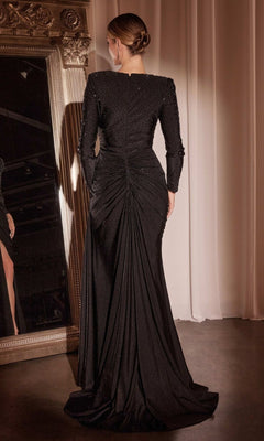 A woman with an elegant updo models the CLCD788 Long Sleeve Long Beaded Prom Dress, featuring a textured, ruched back, as she stands before a large ornate mirror.