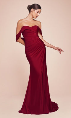 A woman models the Ladivine CD790, an elegant off-the-shoulder long prom dress with fitted ruching and a floor-length satin silhouette, standing against a plain beige background for a timeless look.