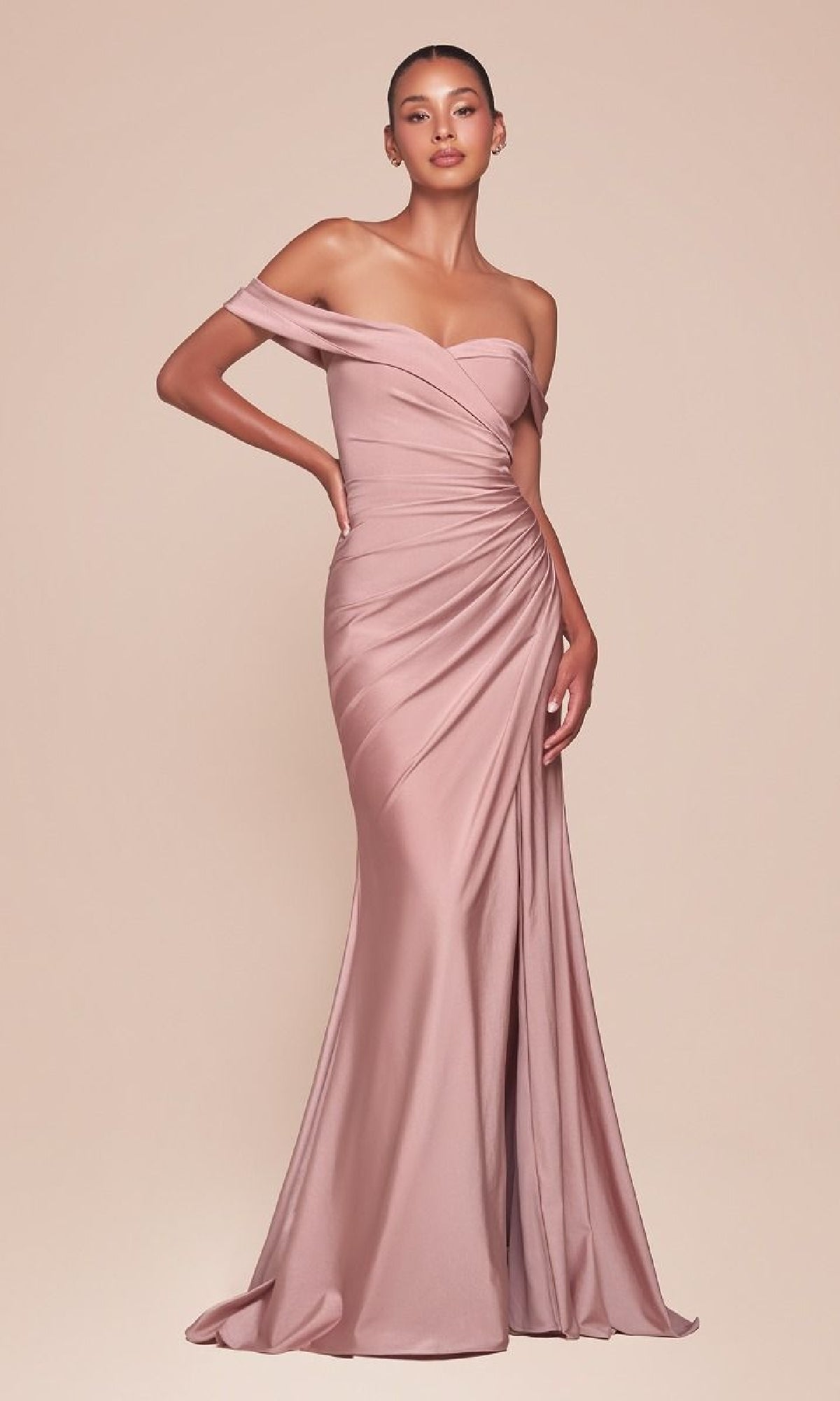 A woman wears the Ladivine CD790, an off-the-shoulder long prom dress in blush pink with ruched detailing and a fitted silhouette, posing elegantly against a neutral background.