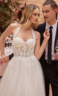 A woman in an Off White Long Halter Wedding Dress CD827W stands next to a man in a black suit and tie, holding a wine glass.
