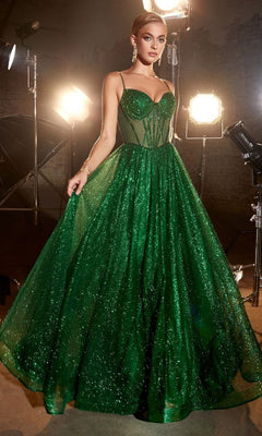 A woman stands in a studio, surrounded by professional lighting, wearing the Sheer-Bodice Long A-Line Shimmer Prom Dress CD832 with its sparkling green fitted corset bodice.