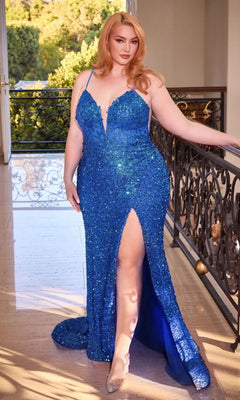 A woman models the V-Neck Plus-Size Long Sequin Prom Dress CD840C, a sparkling blue gown with a thigh-high slit, posing indoors by a decorative railing with greenery outside.