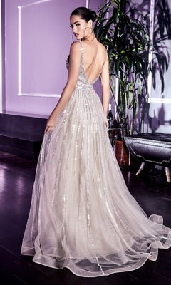 A woman stands indoors on a dark floor, looking over her shoulder while wearing the Ladivine CD940 Glitter-Tulle Long Prom Dress. A large plant and modern decor appear in the background.