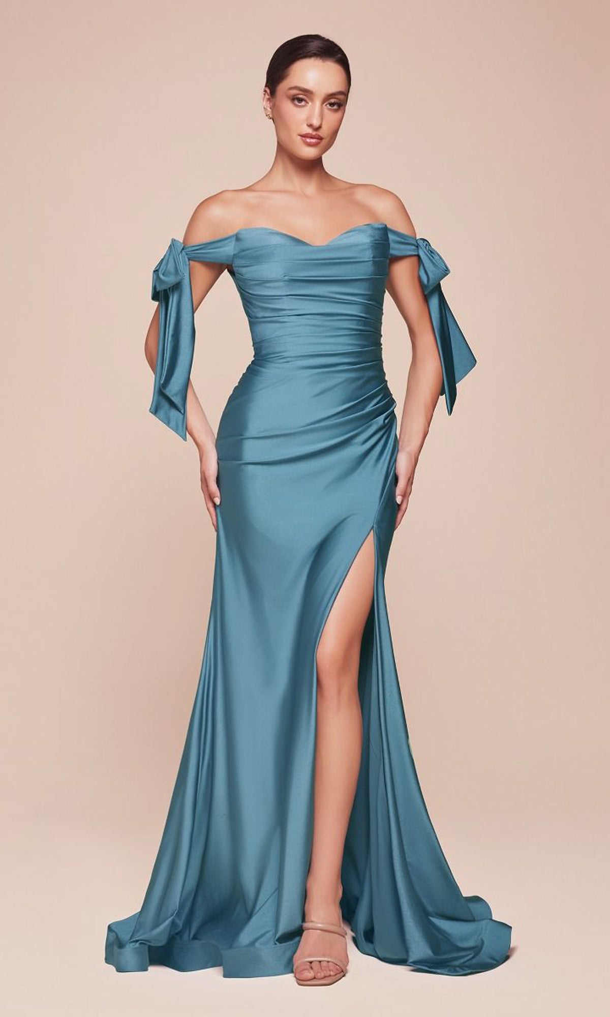 Plus-Size Long Prom Dress with Bows CD943C: Woman in teal off-the-shoulder gown featuring a ruched bodice, side slit, and bow accents on the sleeves, posed against a plain beige background.