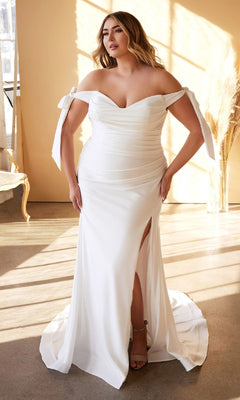 A woman stands indoors, beautifully lit by natural light, wearing the Ladivine CD944WC—a long plus-size bridal dress featuring an off-shoulder neckline and a thigh-high slit.