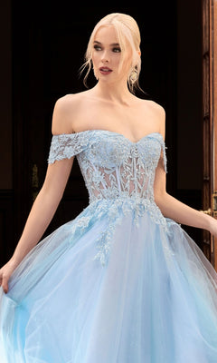 A woman stands indoors wearing the Sheer-Bodice Long Glitter Prom Ball Gown CD961, a light blue, off-the-shoulder dress with lace and tulle details, elegantly holding the skirt.