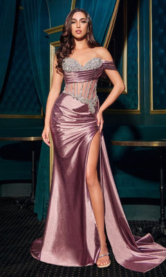 A woman stands in a room wearing the Beaded-Corset Long Prom Dress: Ladivine CDS542, a metallic mauve satin gown with a high slit, sheer beaded corset details, and crystal embellishments.