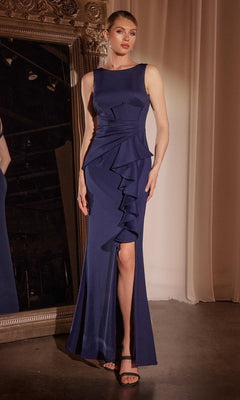 A woman stands indoors beside a large ornate mirror wearing the Ladivine CH377 Drape-Front Long Prom Dress, a stunning plus-size navy gown with ruffled detail and a thigh-high slit.