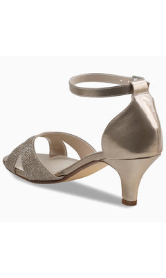 The Clementine Champagne Glitter Prom Shoes by Touch Ups 4614 feature a metallic finish, low kitten heel, open toe, ankle strap, and textured front detailing, shown from a rear side angle.
