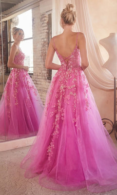 A woman wearing the Long Prom Ball Gown with Flowers CM347 faces a mirror in a softly lit, rustic room, her back to the camera as she admires her reflection.