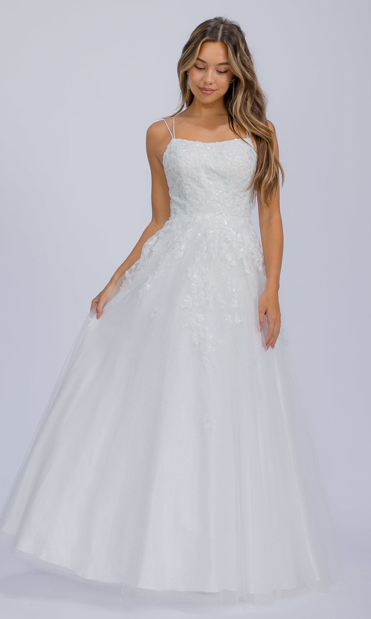 A woman models the Eureka EK197 Floral-Lace Long Prom Ball Gown, a white sleeveless floor-length dress with thin straps and sequin lace details, standing against a plain light background.