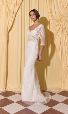 A woman in the Long Formal Dress: Eureka EK209, a fitted mermaid lace gown with sheer sleeves, stands on a checkered floor before yellow draped curtains.