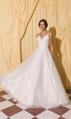 Woman in a Long Prom Dress: Eureka EK210, white, sleeveless, A-line with lace and 3D floral appliques stands on a checkered floor before cream draped curtains.