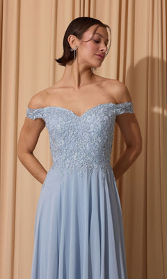 A woman in the Long Prom Dress: Eureka EK211, featuring an off-the-shoulder lace applique bodice and pockets, stands against beige curtains.