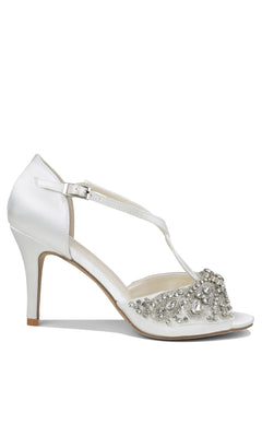 Elin Ivory Satin Prom Shoes by Paradox London (P2204) feature stiletto high heels, a T-strap with ankle buckle, open toe, and jeweled rhinestones and beads on the front for a stunning formal look.