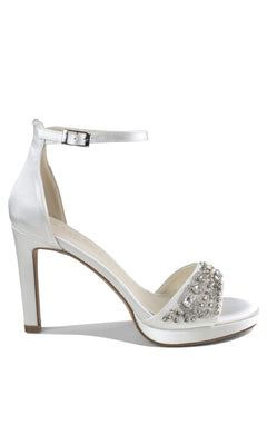 Step out in style with the Enya Ivory Satin Prom Shoes: Paradox London P2203—white jeweled stiletto heels featuring an ankle strap, open toe, and sparkling silver rhinestones, perfect for your next formal event.