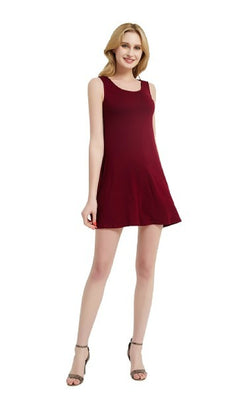 A woman wears a Sleeveless Casual Short T-Shirt Dress with Pockets and gray high-heeled sandals, standing against a white background.