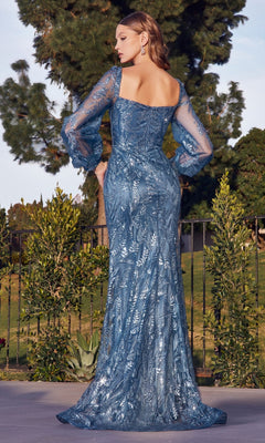A woman stands outdoors in a garden, facing away, wearing the Long Sleeve Long Glitter-Print Formal Dress J816—featuring a blue glitter print, sheer sleeves, and a square neckline.