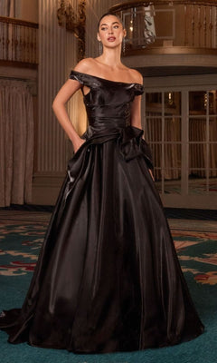 A woman stands indoors on a decorative carpet, wearing the Ladivine J885 Long Prom Dress—an off-the-shoulder satin gown with a full A-line skirt that exudes elegance and timeless sophistication.