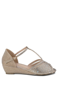 The Janelle Champagne Prom Shoes by Paradox London (P2209) feature gold glittery low wedge heels, an ankle strap, open toe, and rhinestone decoration. Seen in side profile against a white background.