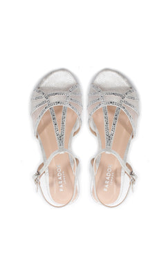 The Jilly Silver Prom Shoes (Paradox London P2001) feature glitter details, beaded and ankle straps, and low wedge heels in a formal design, shown from an overhead view.